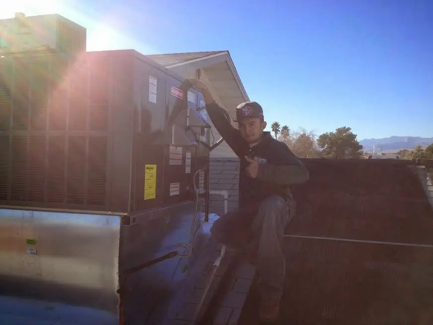 HVAC technician performing AC Tune-Up on a rooftop unit in Memphis